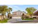 Charming two-story home featuring a three-car garage, stone accents, and lush landscaping at 8801 Rozetta Ct, Las Vegas, NV 89134