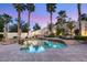 Beautiful pool area with a waterfall feature, lush landscaping, and ample seating and shade at 8801 Rozetta Ct, Las Vegas, NV 89134