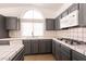 View of kitchen featuring gray cabinets, tiled countertops, a sink, and modern appliances at 9044 Crimson Clover Way, Las Vegas, NV 89134