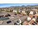 Expansive aerial view of a neighborhood featuring desert landscaping and solar panels with mountain views at 9284 Lopseed Ct, Las Vegas, NV 89149