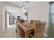 Charming dining area featuring a wooden table with wicker chairs and modern lighting, adjacent to the bright kitchen at 9284 Lopseed Ct, Las Vegas, NV 89149