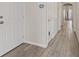 Inviting hallway with wood-look tile flooring and white doors, creating a bright and clean transition space at 9284 Lopseed Ct, Las Vegas, NV 89149