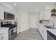 Galley kitchen with white cabinets, stainless steel appliances and modern hardware at 9284 Lopseed Ct, Las Vegas, NV 89149