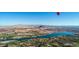 Expansive aerial view of a lake community nestled among mountains, with a red hot air balloon at 100 Via Franello, Henderson, NV 89011