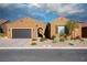 Charming single-story home with a desert landscape, brick driveway, and a two-car garage at 1130 Calico Rdg, Mesquite, NV 89034