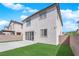 Backyard features artificial grass, concrete, stucco wall and sliding glass doors to the home at 375 Elks Peak Ave, North Las Vegas, NV 89084