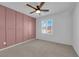 Bedroom with accent wall, ceiling fan, and window with plantation shutters at 375 Elks Peak Ave, North Las Vegas, NV 89084
