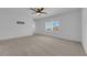 Bedroom featuring plush carpet, neutral paint, ceiling fan and large window with shutters at 375 Elks Peak Ave, North Las Vegas, NV 89084