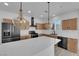 Gourmet kitchen boasts stainless appliances, quartz countertops and island with pendant lighting at 375 Elks Peak Ave, North Las Vegas, NV 89084