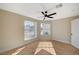 This bedroom has light wood flooring, neutral walls, a ceiling fan and two large windows at 4010 Herblinda Ln, North Las Vegas, NV 89032