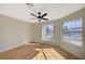 This bedroom has light wood flooring, neutral walls, a ceiling fan and two large windows at 4010 Herblinda Ln, North Las Vegas, NV 89032