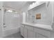Bright white bathroom with dual sinks, granite counters, and tiled shower at 4360 Meadowlark Wing Way, North Las Vegas, NV 89084