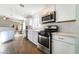 Kitchen boasts stainless appliances, white cabinets, and a view to the living room at 4360 Meadowlark Wing Way, North Las Vegas, NV 89084