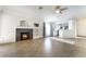 Open living room with a modern fireplace, adjacent to an all-white kitchen at 4360 Meadowlark Wing Way, North Las Vegas, NV 89084