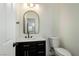 Stylish powder room with black vanity, modern fixtures, and designer mirror at 5774 Typecast Rd, Las Vegas, NV 89142