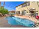 Inviting pool in a backyard with brick coping, string lights, and a patio dining area, ideal for entertaining at 664 Blue Crystal Creek Rd, Henderson, NV 89002