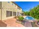 Spacious backyard featuring a private pool, brick patio, mature landscaping, and a two-story home at 664 Blue Crystal Creek Rd, Henderson, NV 89002