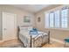 Cozy bedroom with a patterned bedspread, tiled floors, and sun-filled windows with white shutters at 664 Blue Crystal Creek Rd, Henderson, NV 89002
