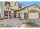 Inviting two-story home with a three-car garage, featuring stone accents and a cozy porch seating area at 664 Blue Crystal Creek Rd, Henderson, NV 89002