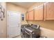 Well-equipped laundry room with a front-loading washer and dryer, plus storage cabinets and decor at 664 Blue Crystal Creek Rd, Henderson, NV 89002