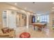 Spacious living area with travertine tile, showcasing archways, a staircase and a billiard table at 664 Blue Crystal Creek Rd, Henderson, NV 89002