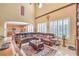 Spacious living area with a sectional sofa, fireplace, and tall windows, open to the dining and kitchen areas at 664 Blue Crystal Creek Rd, Henderson, NV 89002