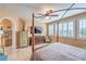 Cozy main bedroom with four poster bed, ceiling fan, and tiled floor at 664 Blue Crystal Creek Rd, Henderson, NV 89002