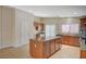 Well-lit kitchen showcasing an island with a granite countertop and tile flooring at 7822 Whitlocks Mill Ave, Las Vegas, NV 89147