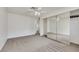 Spacious bedroom with mirrored closet doors and neutral carpet and a ceiling fan at 921 Sulphur Springs Ln # 201, Las Vegas, NV 89128