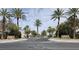 Community entrance with palm trees and manicured landscaping create a welcoming atmosphere at 9324 Pitching Wedge Dr, Las Vegas, NV 89134