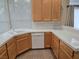 Well-lit kitchen boasts light wood cabinetry, a white tile countertop, a dual basin sink, and stainless steel appliances at 9324 Pitching Wedge Dr, Las Vegas, NV 89134