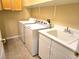 Practical laundry room with washer, dryer, sink, and cabinets for storage at 9324 Pitching Wedge Dr, Las Vegas, NV 89134