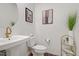 Elegant powder room featuring a pedestal sink, gold faucet, and modern artwork at 2742 Zazzera Ct, Henderson, NV 89044