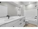 Bathroom featuring double sinks, quartz countertops and a shower-tub combo with white tile at 3240 Walker River St, North Las Vegas, NV 89032