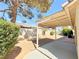Cozy backyard featuring a covered patio, gravel landscaping, mature tree, and privacy wall at 3523 Calf Roper Ct, North Las Vegas, NV 89032
