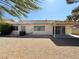 Gravel backyard featuring a covered patio and house exterior with multiple windows at 3523 Calf Roper Ct, North Las Vegas, NV 89032
