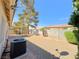 Spacious gravel backyard featuring a covered patio area with mature trees for shade at 3523 Calf Roper Ct, North Las Vegas, NV 89032