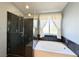Elegant bathroom with a glass enclosed shower and soaking tub with window at 3523 Calf Roper Ct, North Las Vegas, NV 89032