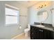 Well-lit bathroom features a vanity with a dark cabinet and granite countertop, plus a round mirror at 3523 Calf Roper Ct, North Las Vegas, NV 89032