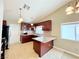 Well-lit kitchen with cherry cabinets, granite counters, an island and stainless steel appliances at 3523 Calf Roper Ct, North Las Vegas, NV 89032