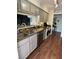 An updated kitchen with stainless appliances, grey cabinets, and wood flooring provides modern convenience and style at 682 Oakmont Ave # 1507, Las Vegas, NV 89109