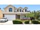 Inviting two-story home featuring a well-manicured lawn, lush landscaping, and attached two-car garage at 7729 Natures Song St, Las Vegas, NV 89131