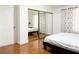 Bright bedroom with mirrored closet doors and wood laminate flooring at 8452 Boseck Dr # 225, Las Vegas, NV 89145
