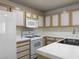 Bright kitchen features tile countertops, white appliances, and wooden cabinets at 8452 Boseck Dr # 225, Las Vegas, NV 89145