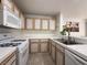 Bright kitchen features tile countertops, white appliances, and wooden cabinets at 8452 Boseck Dr # 225, Las Vegas, NV 89145