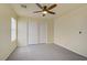 Spacious bedroom featuring neutral walls, carpet flooring, ceiling fan, and a closet with sliding doors at 9932 Keephills St, Las Vegas, NV 89183