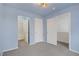 Bedroom featuring neutral walls, carpet flooring, and three open doorways at 9932 Keephills St, Las Vegas, NV 89183