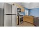 Well-equipped kitchen with stainless steel appliances, light wood cabinets, and light countertops at 9932 Keephills St, Las Vegas, NV 89183