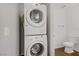 Convenient laundry area with stacked washer and dryer, located next to the downstairs toilet at 9932 Keephills St, Las Vegas, NV 89183