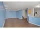 Open-concept living area with wood-look floors, adjacent to kitchen, laundry, and staircase at 9932 Keephills St, Las Vegas, NV 89183